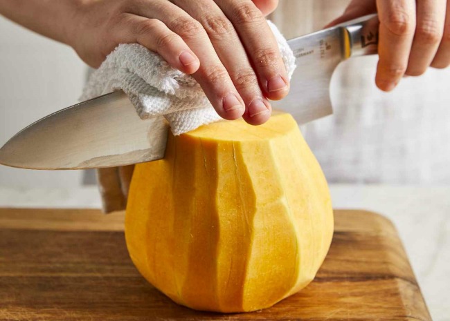 cutting a peeled butternut squash